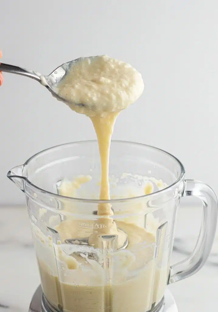 A spoon lifting the pancake batter to show thick but pourable consistency Protein Pancakes with Cottage Cheese