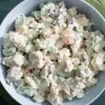Overhead view of a high protein chicken salad in a white bowl on a marble countertop