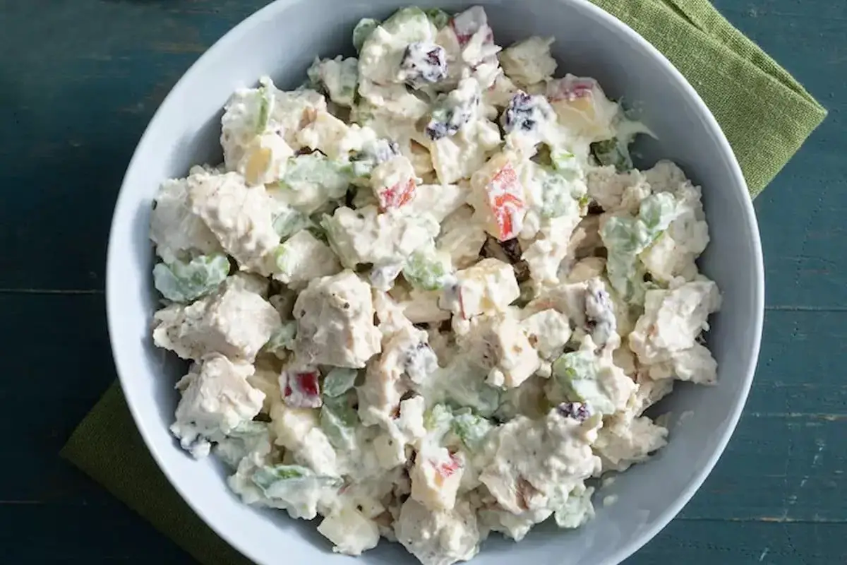 Overhead view of a high protein chicken salad in a white bowl on a marble countertop