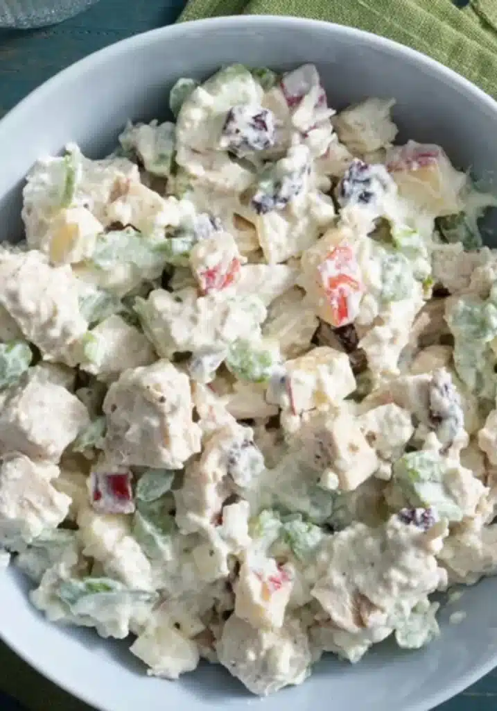 Overhead view of a high protein chicken salad in a white bowl on a marble countertop