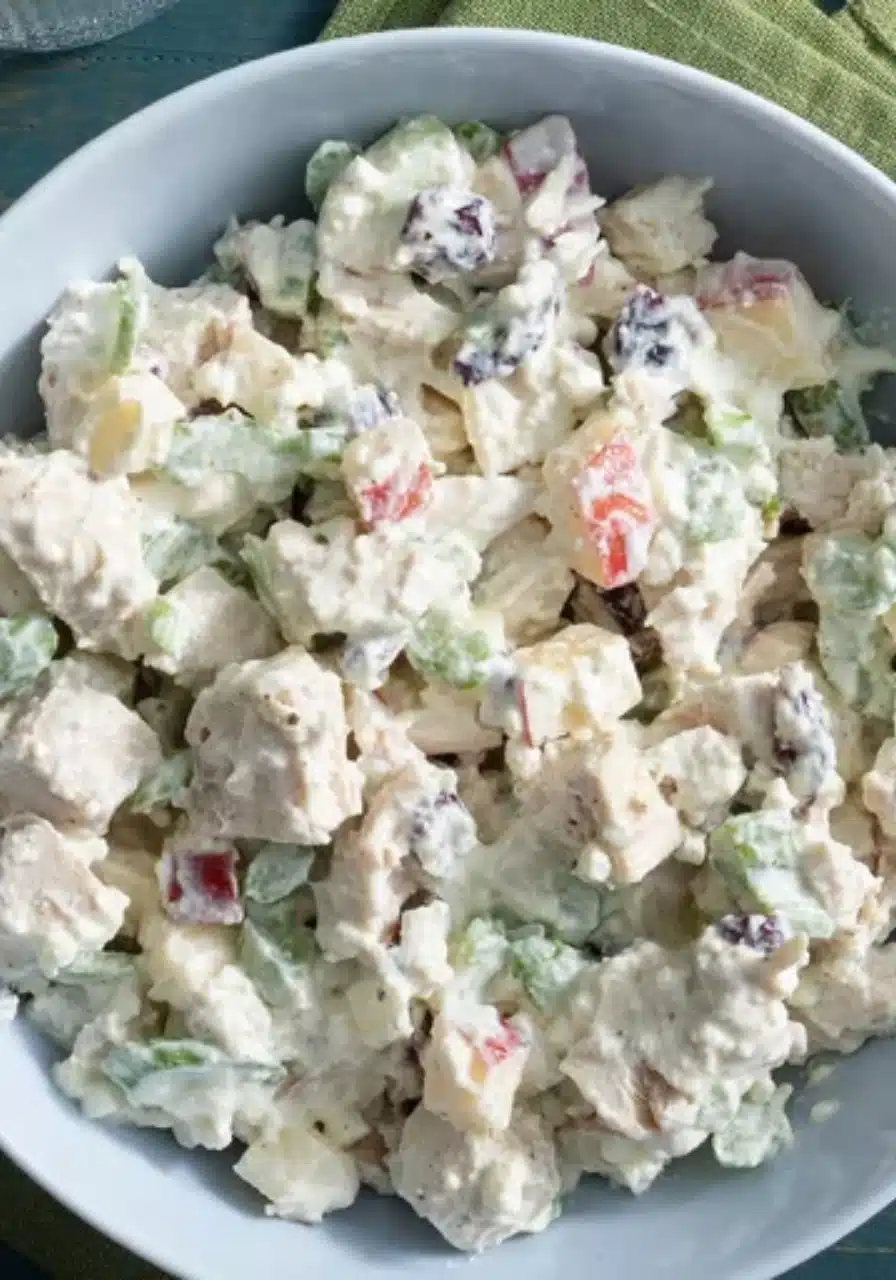 Overhead view of a high protein chicken salad in a white bowl on a marble countertop