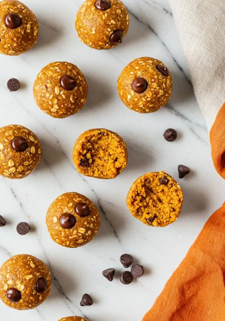 Overhead shot of pumpkin protein balls neatly arranged on a white marble countertop